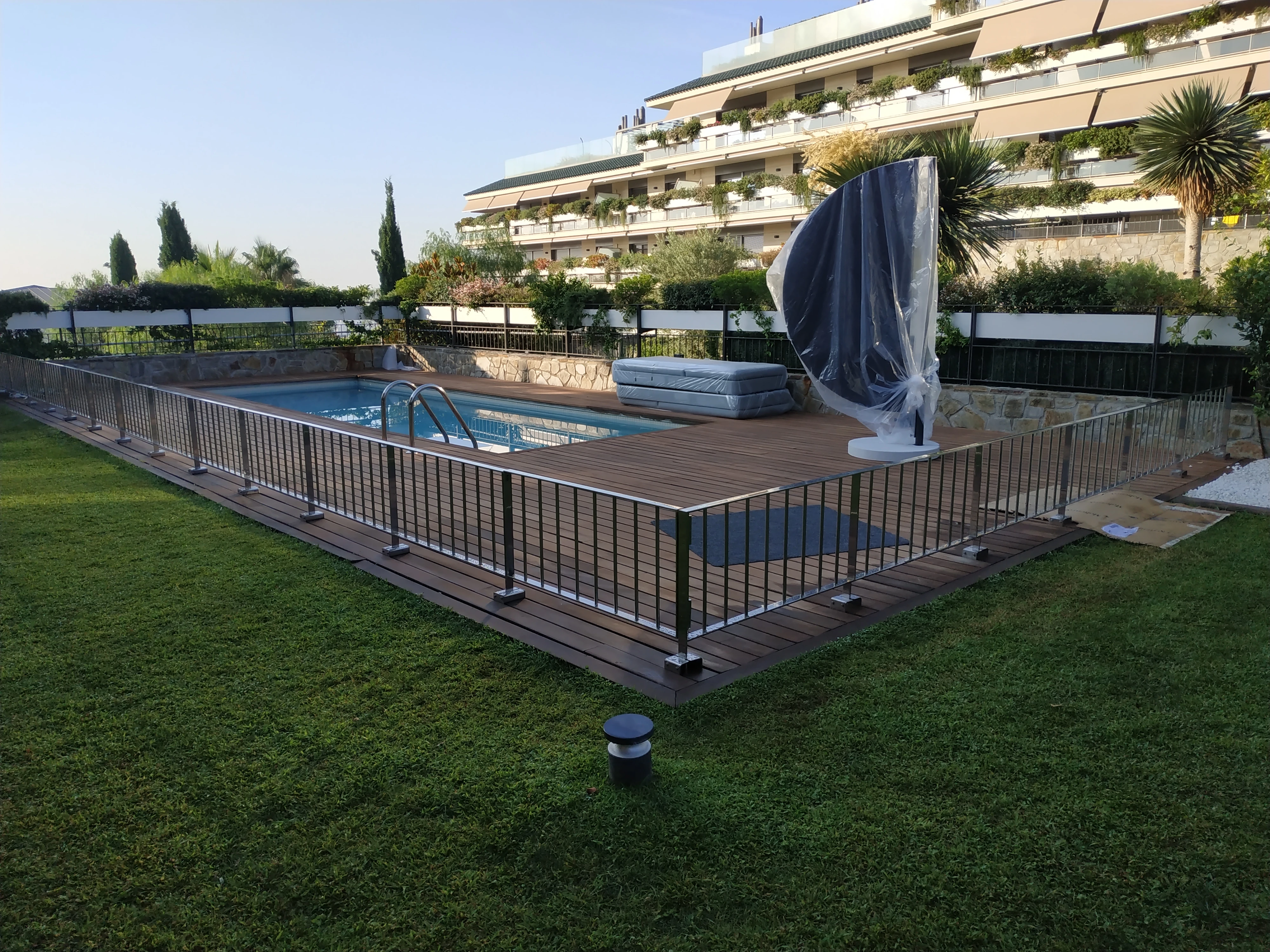 Barandilla perimetral de acero inoxidable en piscina exterior de jardín