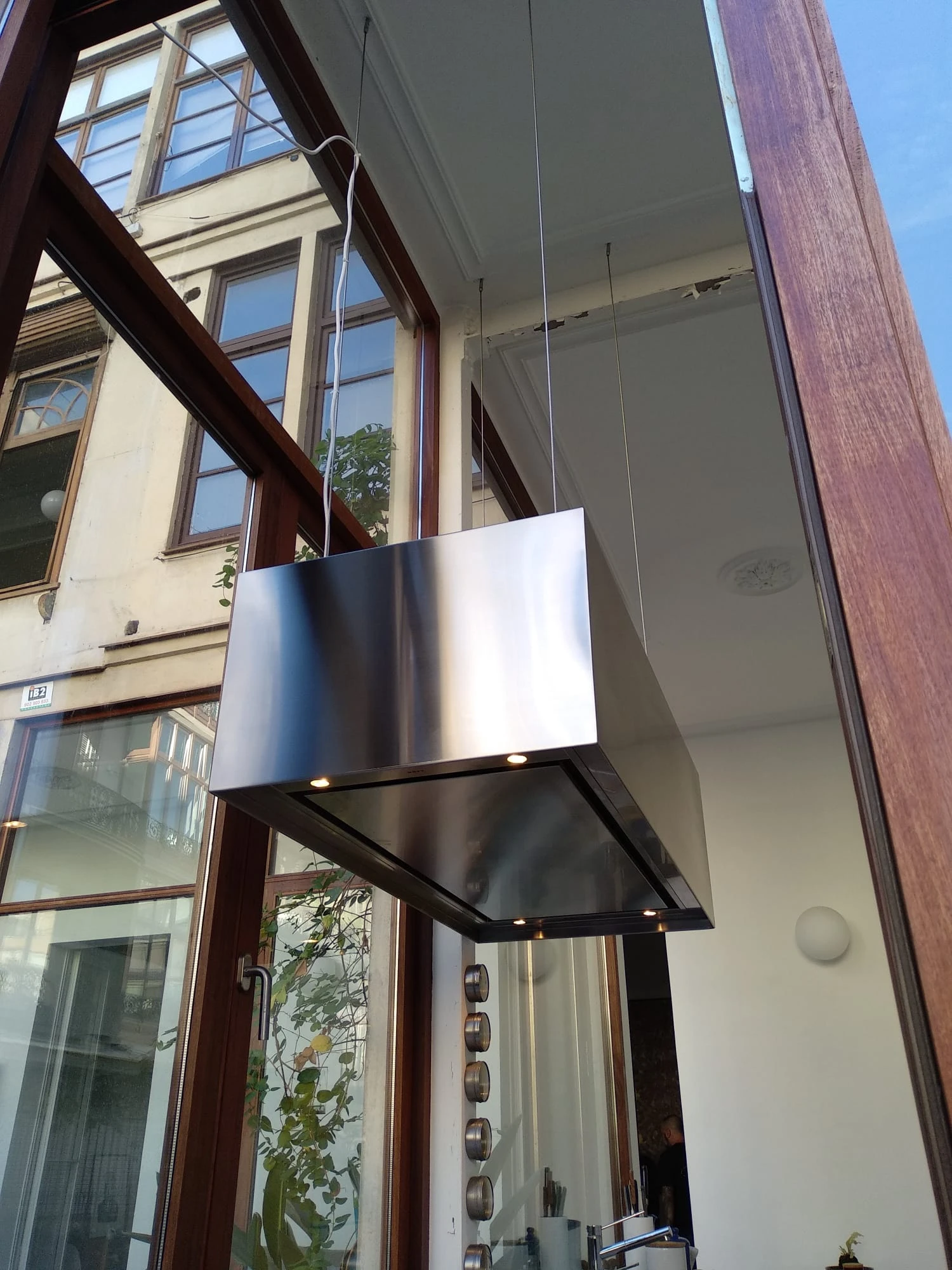 Campana extractora de acero inoxidable suspendida en restaurante boutique