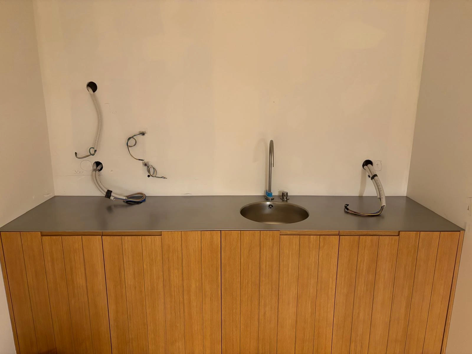 Encimera de acero inoxidable sobre mueble de madera con fregadero oval