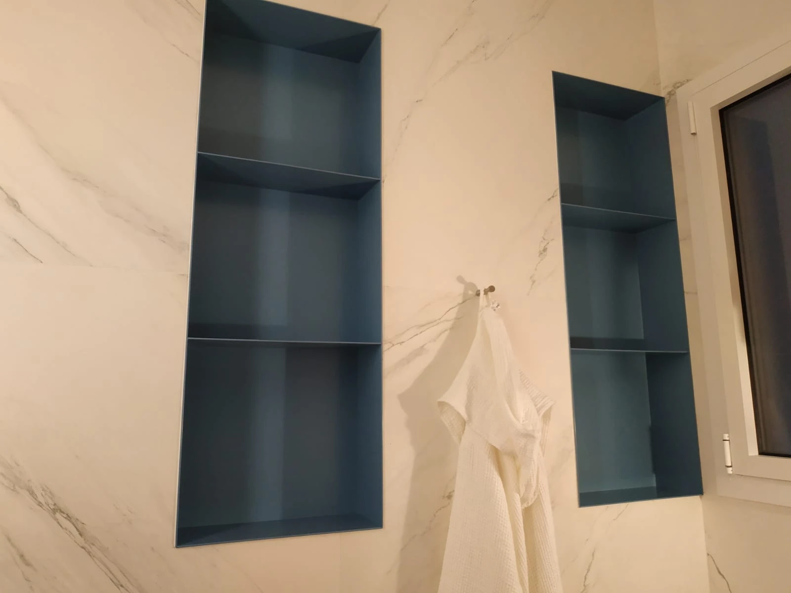 Hornacinas a medida en pared de mármol con interior lacado azul