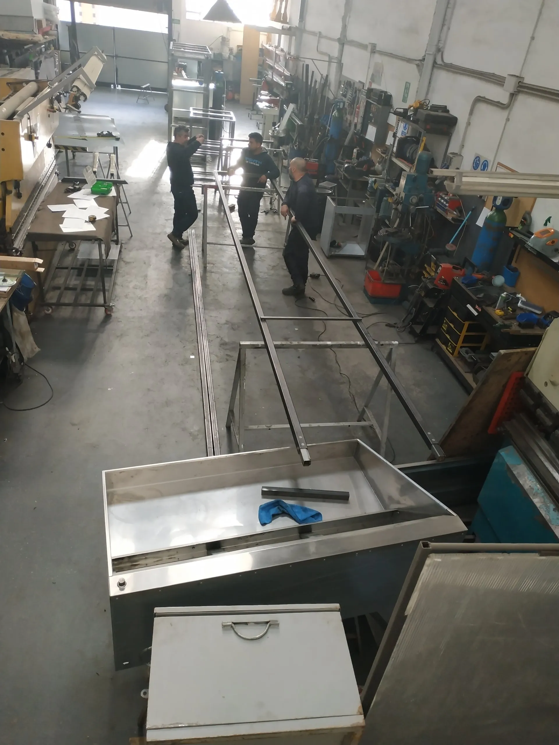Operarios de Inox Carrera Serveis trabajando piezas largas en la nave de fabricación